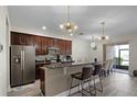 Modern kitchen with stainless steel appliances, granite countertops, a large island, and unique lighting at 8407 Riverdale Ln, Davenport, FL 33896