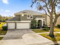 Two-story house with a large driveway and surrounding landscape at 8511 La Isla Dr, Kissimmee, FL 34747