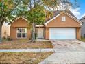 Two-story house with attached garage, landscaping, and a tan exterior at 942 Beresford Way, Lake Mary, FL 32746