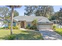 One-story house with a gray roof, a two-car garage, and a landscaped yard at 960 Manchester Ave, Oviedo, FL 32765