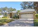 Tan two-story house with a paved driveway and two-car garage at 960 Manchester Ave, Oviedo, FL 32765