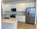 Modern kitchen with white cabinets, stainless steel appliances, and an island at 11141 Green Citron Aly, Winter Garden, FL 34787