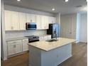 Modern kitchen with white cabinets, stainless steel appliances, and an island at 11141 Green Citron Aly, Winter Garden, FL 34787