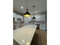 Bright, modern kitchen featuring white cabinets, stone countertops, and stylish pendant lighting at 116 E Cleveland St, Apopka, FL 32703