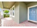 Covered front porch with brick pavers and a light blue front door at 12754 Brodlove Ln, Winter Garden, FL 34787