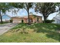 Single Gathering home featuring a well-manicured lawn, mature trees, and a two-car garage at 14101 Vista Del Lago Blvd, Clermont, FL 34711