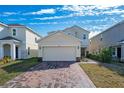 Two-story house with a two-car garage and a brick paver driveway at 1490 Woodmont Blvd, Kissimmee, FL 34746