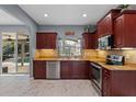 Charming kitchen with stainless steel appliances, granite counters, and cherry wood cabinetry at 1595 Stone Trl, Deltona, FL 32725