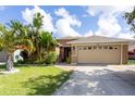 Charming single-Gathering home boasts an attached two-car garage and lush landscaping at 234 Elderberry Dr, Davenport, FL 33897