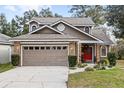 Two-story house with a brown exterior, brick accents, and a two-car garage at 2705 Grantham Ct, Orlando, FL 32835