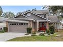 Two-story house with a brown exterior, brick accents, and a two-car garage at 2705 Grantham Ct, Orlando, FL 32835