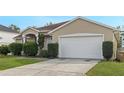 House exterior with a white garage door and landscaping at 63 York Ct, Kissimmee, FL 34758