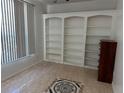 Bright living room featuring built-in shelving and tile flooring with decorative detail at 63 York Ct, Kissimmee, FL 34758