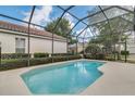 Relaxing screened-in pool with a blue tile interior and plenty of space for lounging at 7403 Velleux St, Reunion, FL 34747