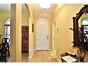 Bright foyer with neutral walls, tile flooring, arched doorways, and a view of the dining area at 10215 Yonaomi Cir, Clermont, FL 34711