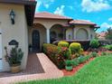 Inviting front entrance featuring a brick walkway, well-maintained landscaping, and a stylish front door at 10215 Yonaomi Cir, Clermont, FL 34711