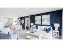 Living room with white couch, blue accent wall, and adjacent dining area at 1705 Frogmore Ave, Haines City, FL 33844