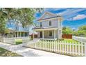 Charming two-story home with a covered front porch, fenced yard, and professionally landscaped lawn at 219 Laurel Ave, Sanford, FL 32771