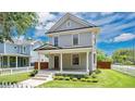 Charming two-story home with a covered front porch and beautiful landscaping on a well-maintained lawn at 219 Laurel Ave, Sanford, FL 32771