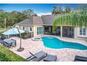 Aerial view of the backyard featuring a sparkling pool, spa, patio furniture, and lush landscaping at 278 Eaglet Way, Lake Mary, FL 32746