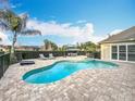 Backyard pool with lounge chairs and an umbrella-covered dining table on a brick patio at 278 Eaglet Way, Lake Mary, FL 32746