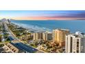 Beautiful aerial view showcases beachfront condos, palm trees, and ocean at sunset at 2901 S Atlantic Ave # 702, Daytona Beach, FL 32118