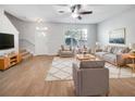 Bright living room features hardwood floors, comfy seating, and large windows at 510 Rainbow Springs Loop, Groveland, FL 34736