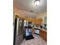 Galley kitchen with stainless steel appliances at 517 Cardinal Dr, Kissimmee, FL 34759