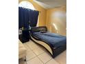 Bedroom with a modern bed frame and window with black curtains at 6868 Westlake Blvd, Orlando, FL 32810
