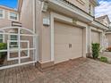 Two-car garage with tan door and white gate at 8307 Fontera Dr, Davenport, FL 33896