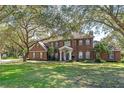 Charming two-story red brick home with a well-manicured lawn and mature trees at 9501 Hempel Cove Blvd, Windermere, FL 34786
