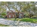 Charming two-story red brick home with a well-manicured lawn and mature trees at 9501 Hempel Cove Blvd, Windermere, FL 34786