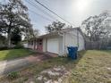 White garage door and brick facade, with a large yard at 990 Liskeard Ave, Orange City, FL 32763