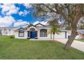 White house with blue door, landscaping, and driveway at 245 Heronwood Cir, Deltona, FL 32725