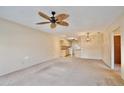 Living room with ceiling fan, carpet, and view into kitchen at 12340 Tavares Ridge Ln # 111, Tavares, FL 32778