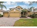 Two-story house with a three-car garage and brick driveway at 1395 Legendary Blvd, Clermont, FL 34711