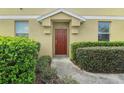 A close up of a front entrance shows a decorative front door and manicured shrubs and lawn at 1604 Scarlet Oak Loop # B, Winter Garden, FL 34787