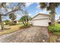 Exterior view of a house with a brick driveway and lush landscaping at 212 Rialto Rd, Kissimmee, FL 34759