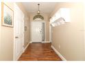 Bright and airy entryway with hardwood floors and built-in shelving at 30129 Pga Dr, Sorrento, FL 32776