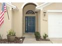 Inviting front entrance with a dark blue door and a decorative archway at 30129 Pga Dr, Sorrento, FL 32776