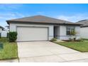 House exterior featuring a two-car garage and landscaping at 309 Citrus Isle Loop, Davenport, FL 33837