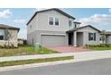 Side view of a modern two-story home with a brick driveway and well-maintained lawn at 3833 Giorgio Dr, Winter Haven, FL 33884