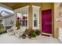 Covered porch with white wicker chairs and potted plants at 4220 Cleary Way, Orlando, FL 32828