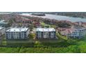 An aerial view of a luxurious waterfront condominium complex with beautifully manicured grounds and stunning water views at 432 Bouchelle Dr # 102, New Smyrna Beach, FL 32169
