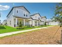 A street showcasing new two-story homes with inviting front porches and well-kept lawns in a modern community at 5003 Railroad Vine Aly, Winter Garden, FL 34787