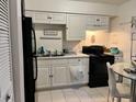 Bright kitchen with white cabinetry, black appliances, and tile flooring at 5885 Dahlia Dr # 24, Orlando, FL 32807