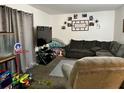 Cozy living room features neutral tones, a sectional couch, and a TV at 5885 Dahlia Dr # 24, Orlando, FL 32807