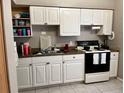 Efficient kitchen with white cabinetry and black appliances at 5885 Dahlia Dr # 31/116, Orlando, FL 32807