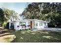 Mid-century modern home with a pink door and manicured lawn at 7007 Seminole Dr, Belle Isle, FL 32812