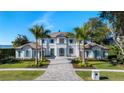 Luxury waterfront home with palm trees and a paver driveway at 9122 Bay Point Dr, Orlando, FL 32819